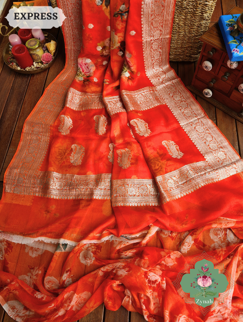 A pure Khaddi Georgette Banarasi saree with intricate silver zari work & floral pattern, perfect for weddings & formal events.