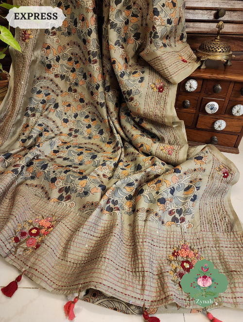 Sage green saree with Frenchknot motifs & Kantha embroidery on jute tussar Kalamkari fabric. Sequins on pallu & border.