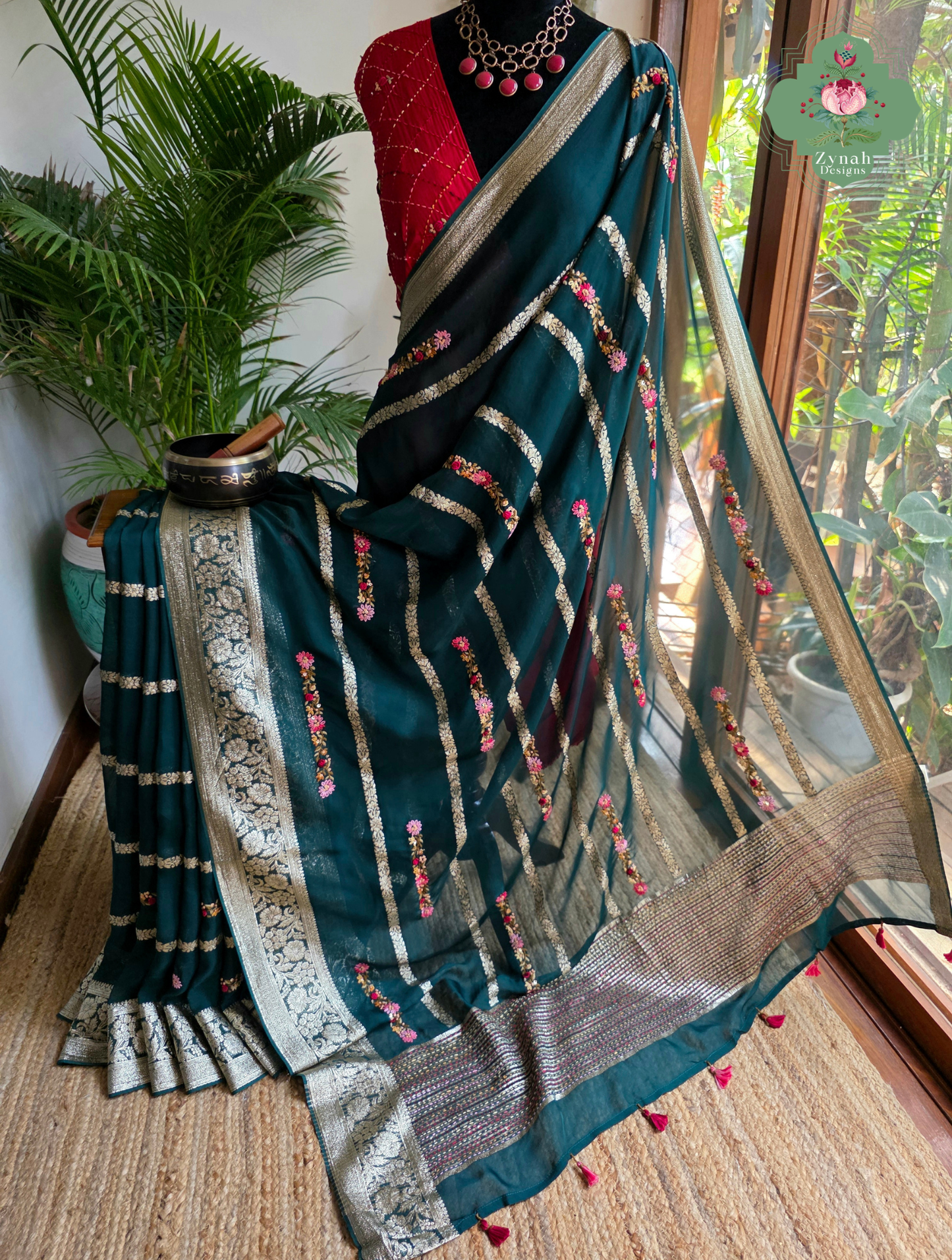 Zynah Émeraude Rêverie – Bottle Green Organza Crepe Silk Saree with Gold Zari Borders, Stripes & French Knot Hand Embroidery