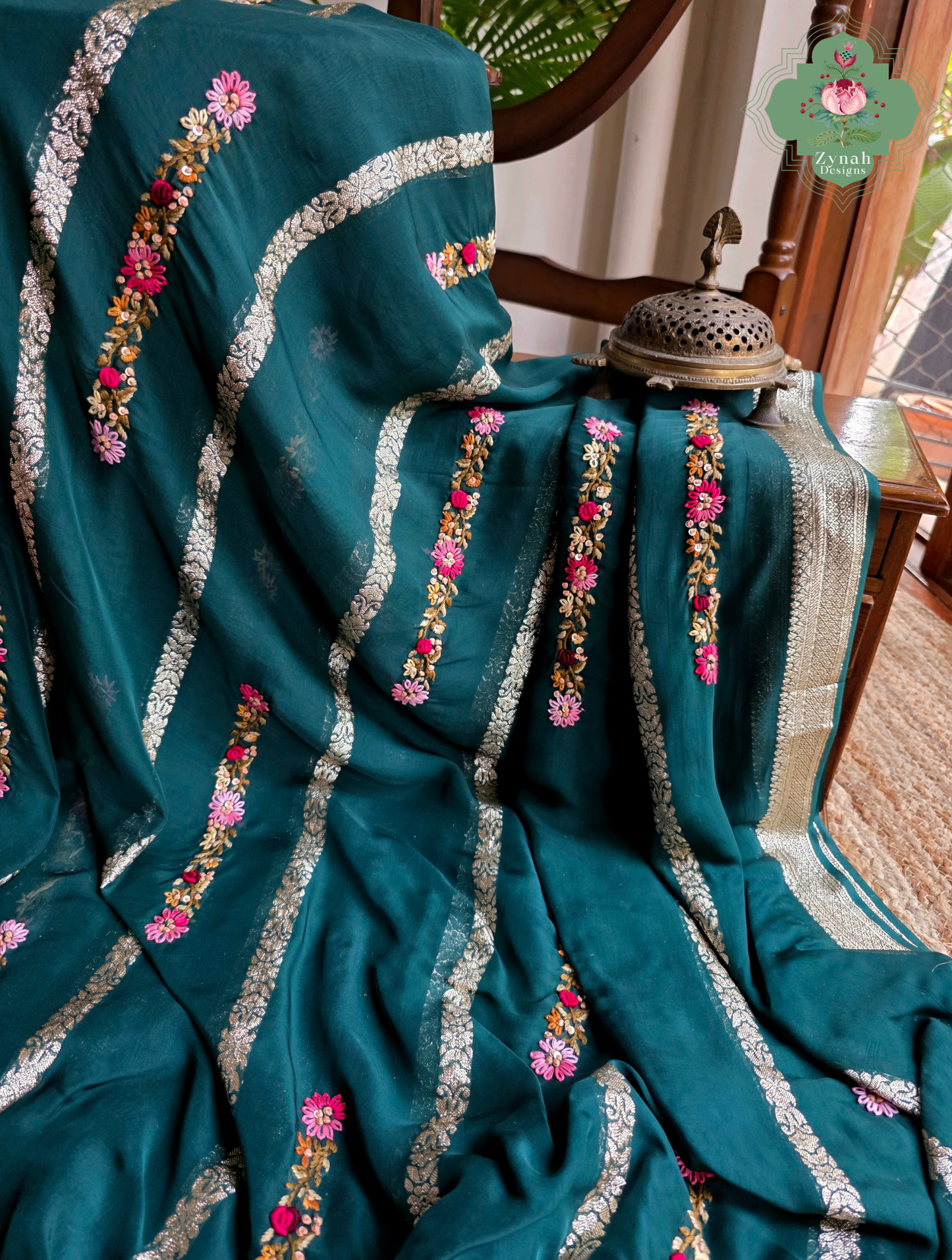 Zynah Émeraude Rêverie – Bottle Green Organza Crepe Silk Saree with Gold Zari Borders, Stripes & French Knot Hand Embroidery
