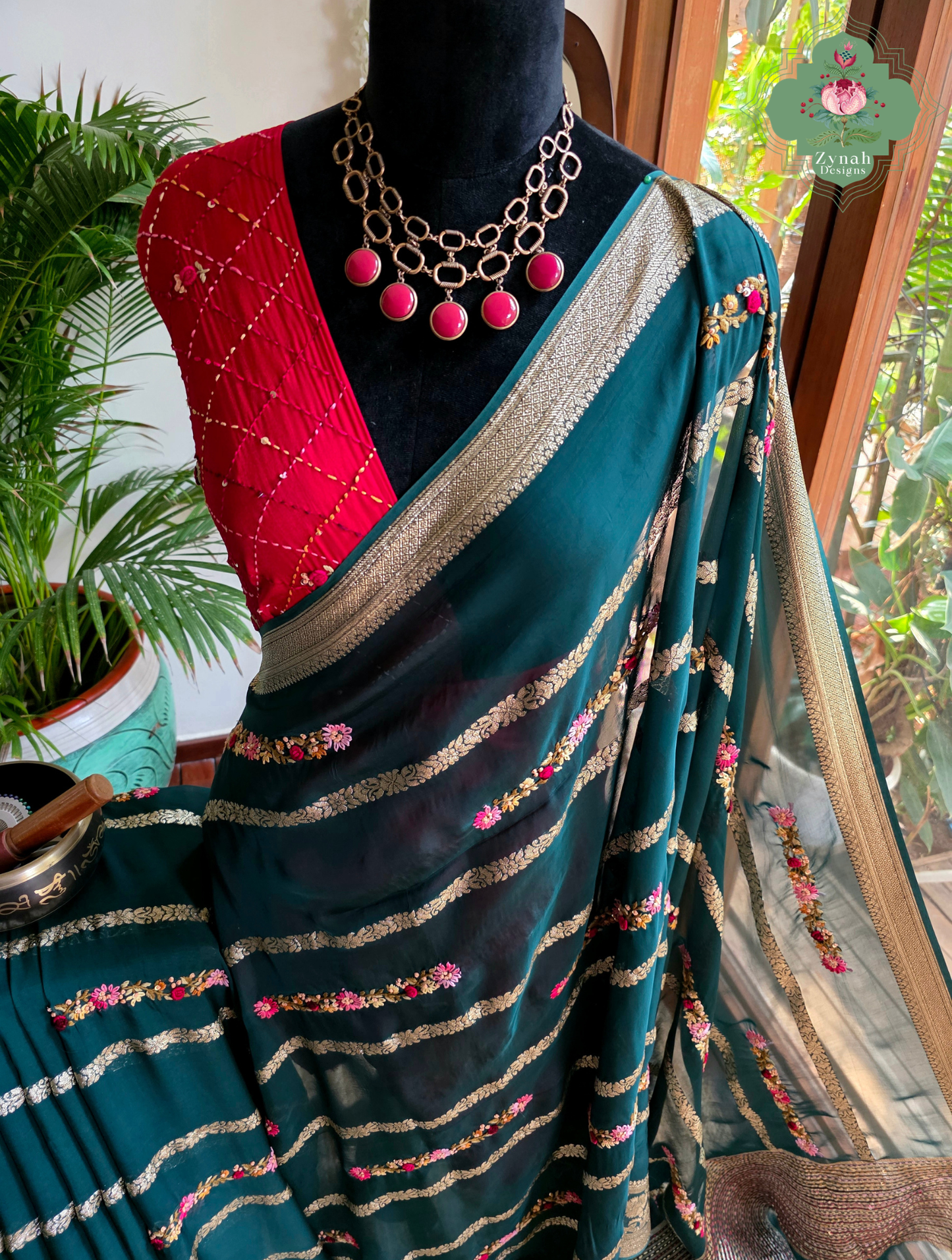 Zynah Émeraude Rêverie – Bottle Green Organza Crepe Silk Saree with Gold Zari Borders, Stripes & French Knot Hand Embroidery