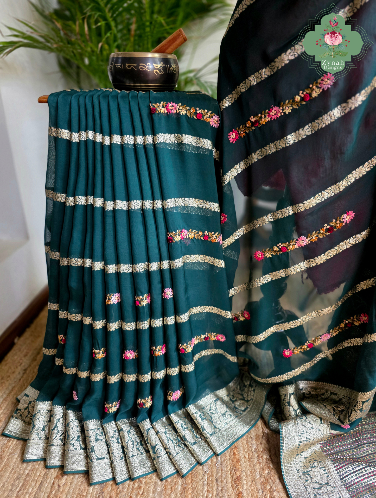 Zynah Émeraude Rêverie – Bottle Green Organza Crepe Silk Saree with Gold Zari Borders, Stripes & French Knot Hand Embroidery