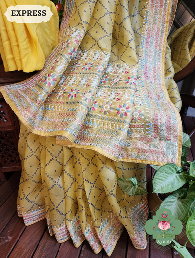 Lemon Yellow Organza Silk Saree: Bandhani prints & multi-colored embroidery. Effortless grace and vibrant charm combined.