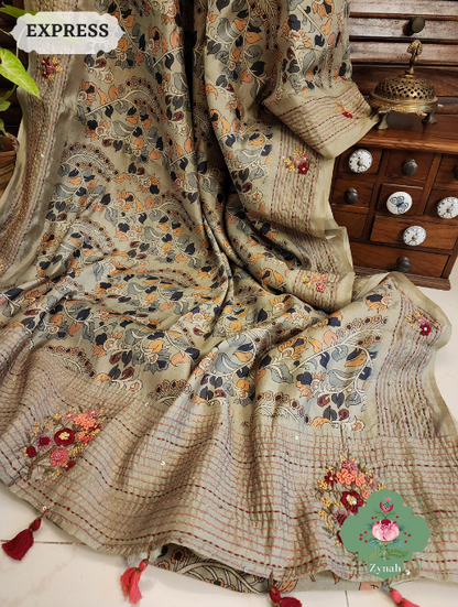 Sage green saree with Frenchknot motifs & Kantha embroidery on jute tussar Kalamkari fabric. Sequins on pallu & border.