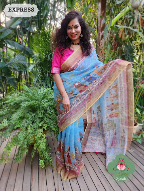 Elegant blue linen saree w/ Pichwai print & zari border. Versatile for special events. Traditional design with a modern twist.