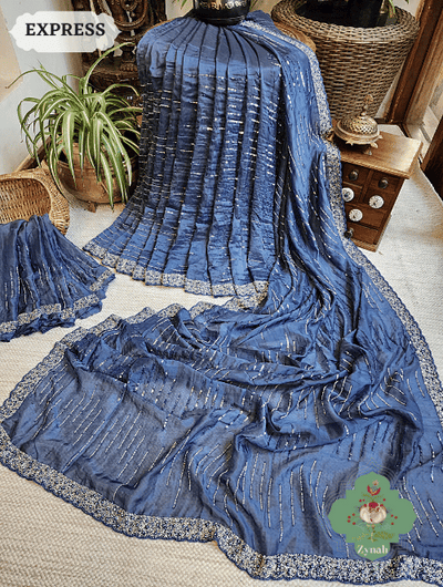 A beautiful blue satin organza silk saree with intricate cutdana, sequins and pearl work, perfect for a special occasion.