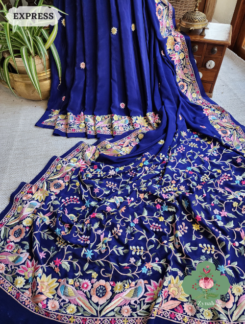 A stunning Navy Blue saree made of Crepe Silk with exquisite Hand-Embroidered Parsi Gara work. Traditional and elegant.