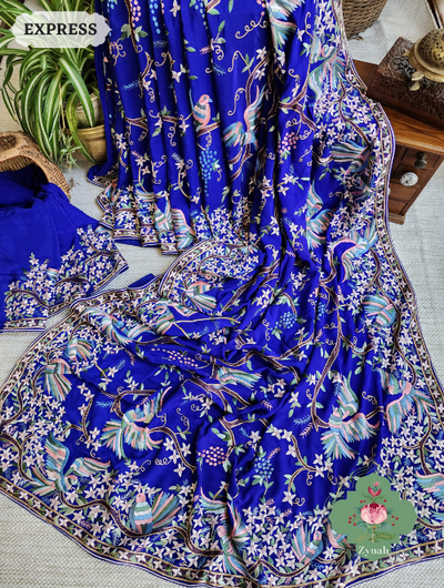 An opulent Royal Blue saree crafted from Pure Crepe Silk with intricate Hand-Embroidered Parsi Gara work.  